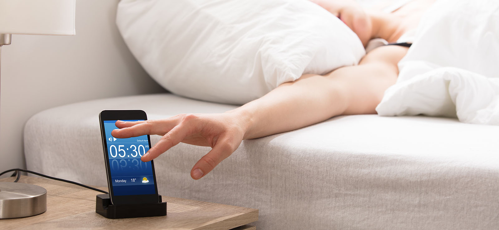 person turing off an alarm clock