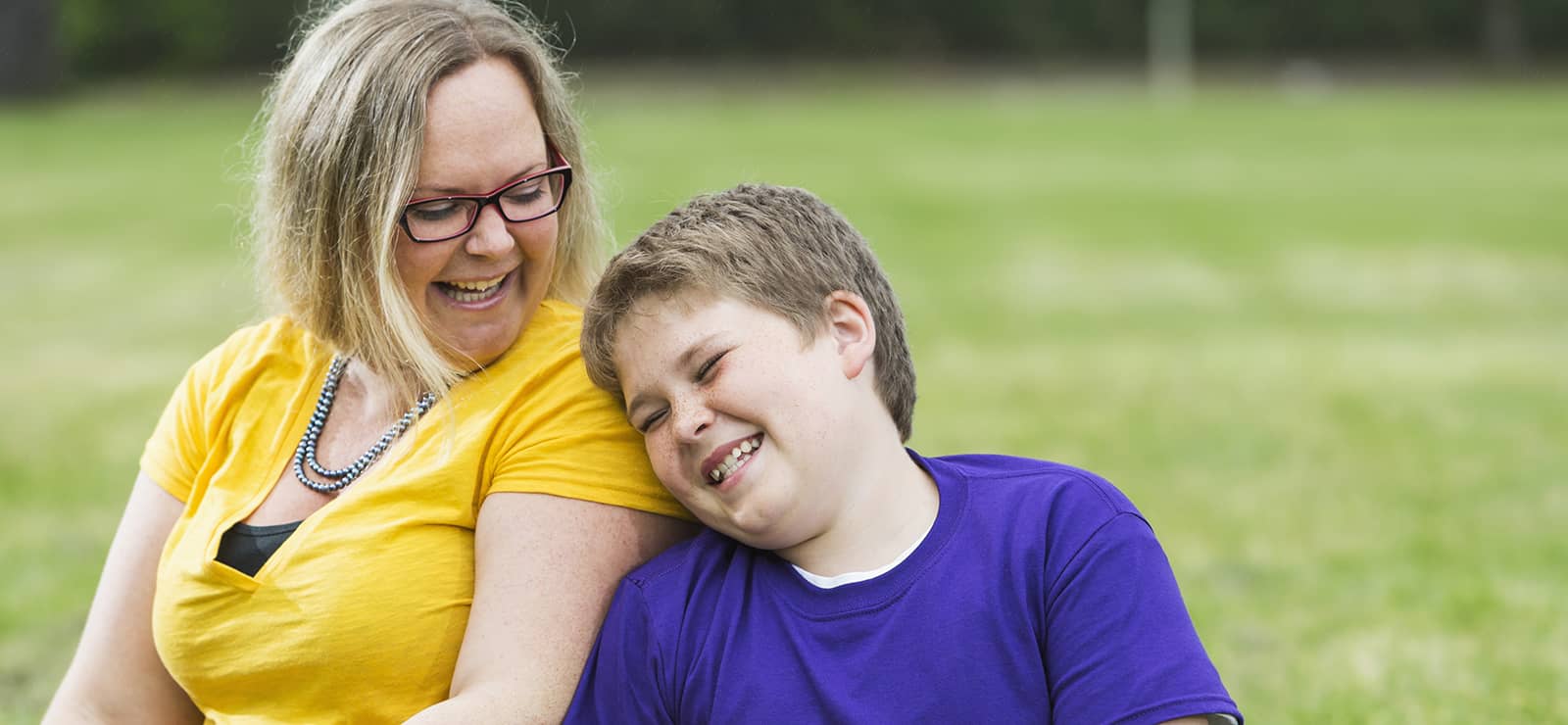 Mother and son sitting outside laughing