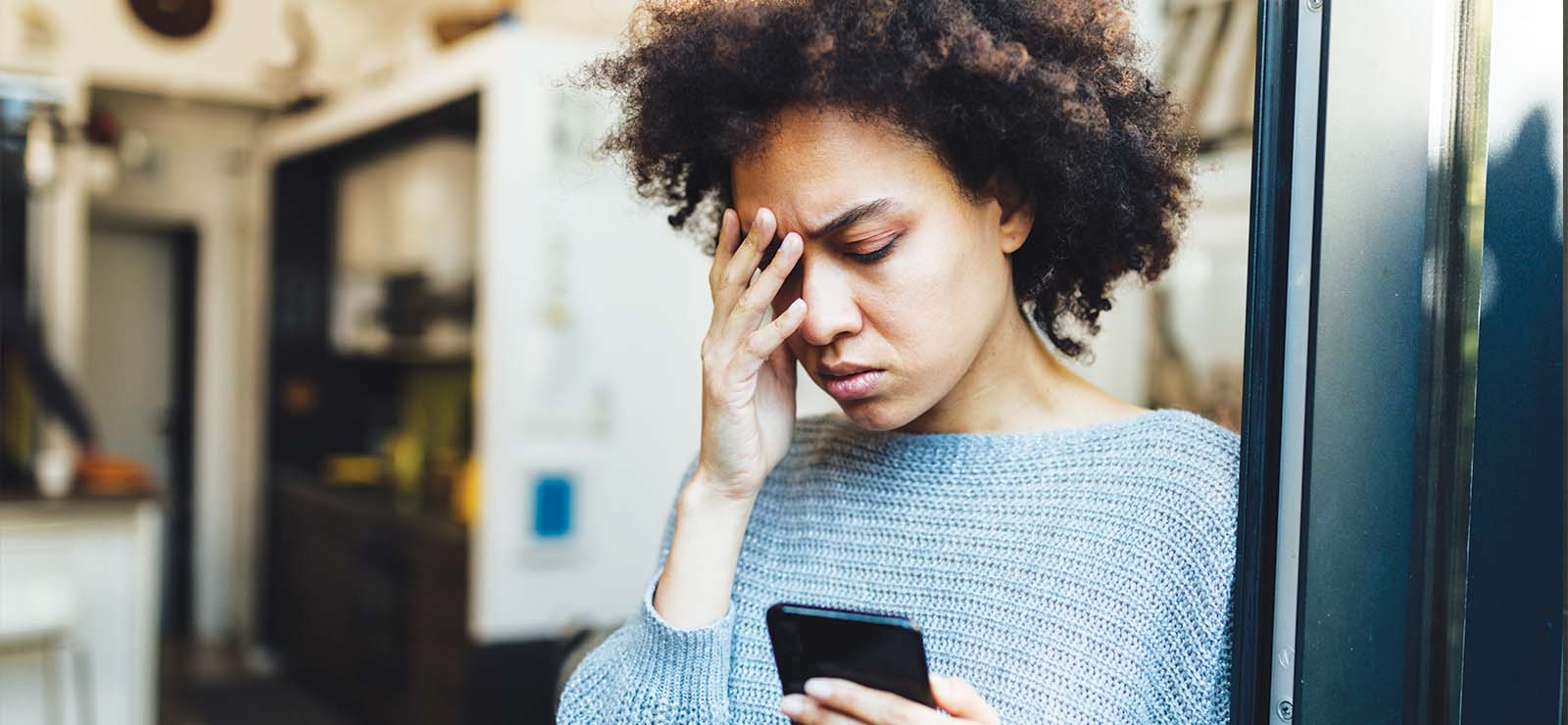 Woman touching her forehead in pain