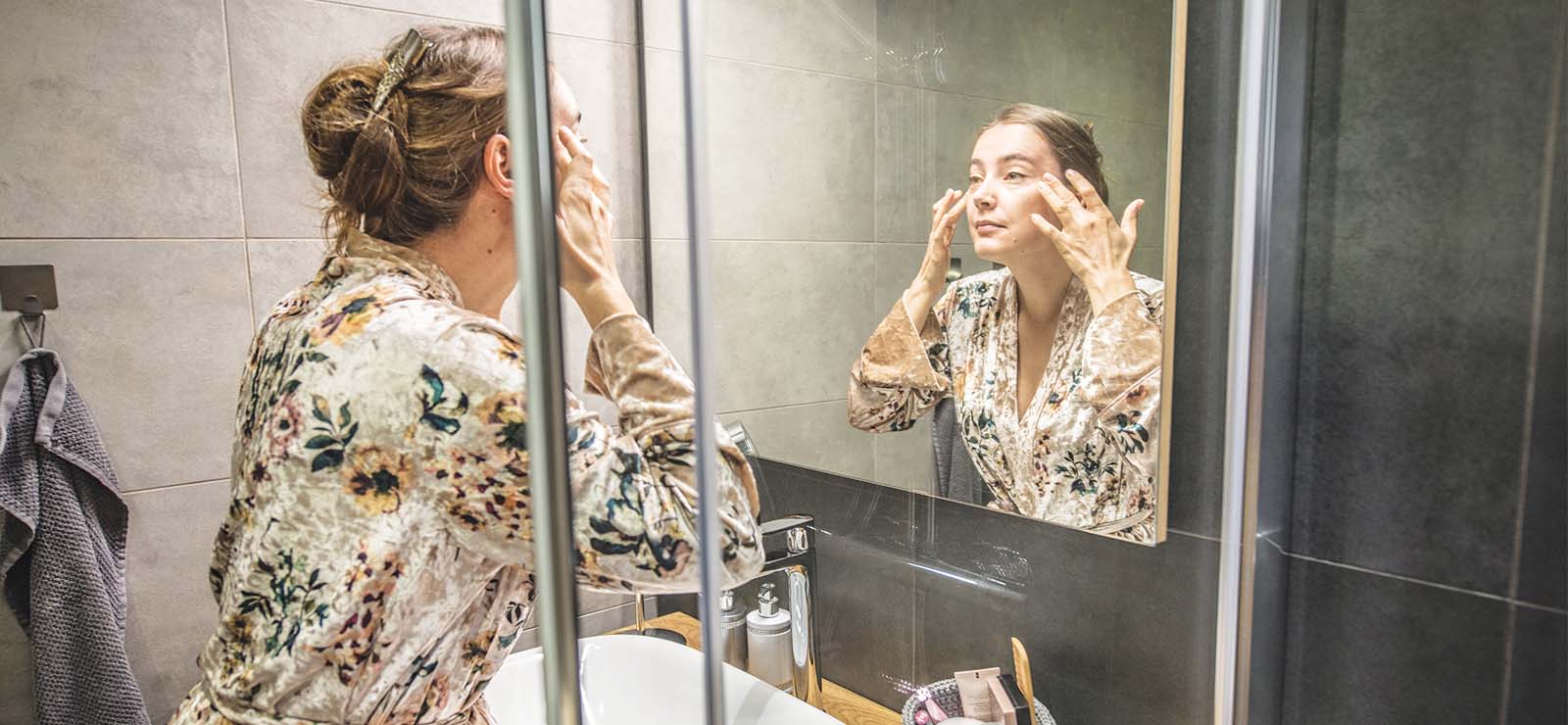Woman looking at her face in the mirror
