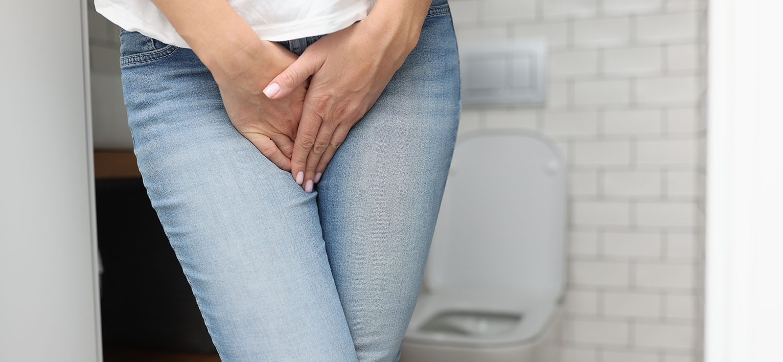 Woman standing uncomfortably due to weak pelvic floor