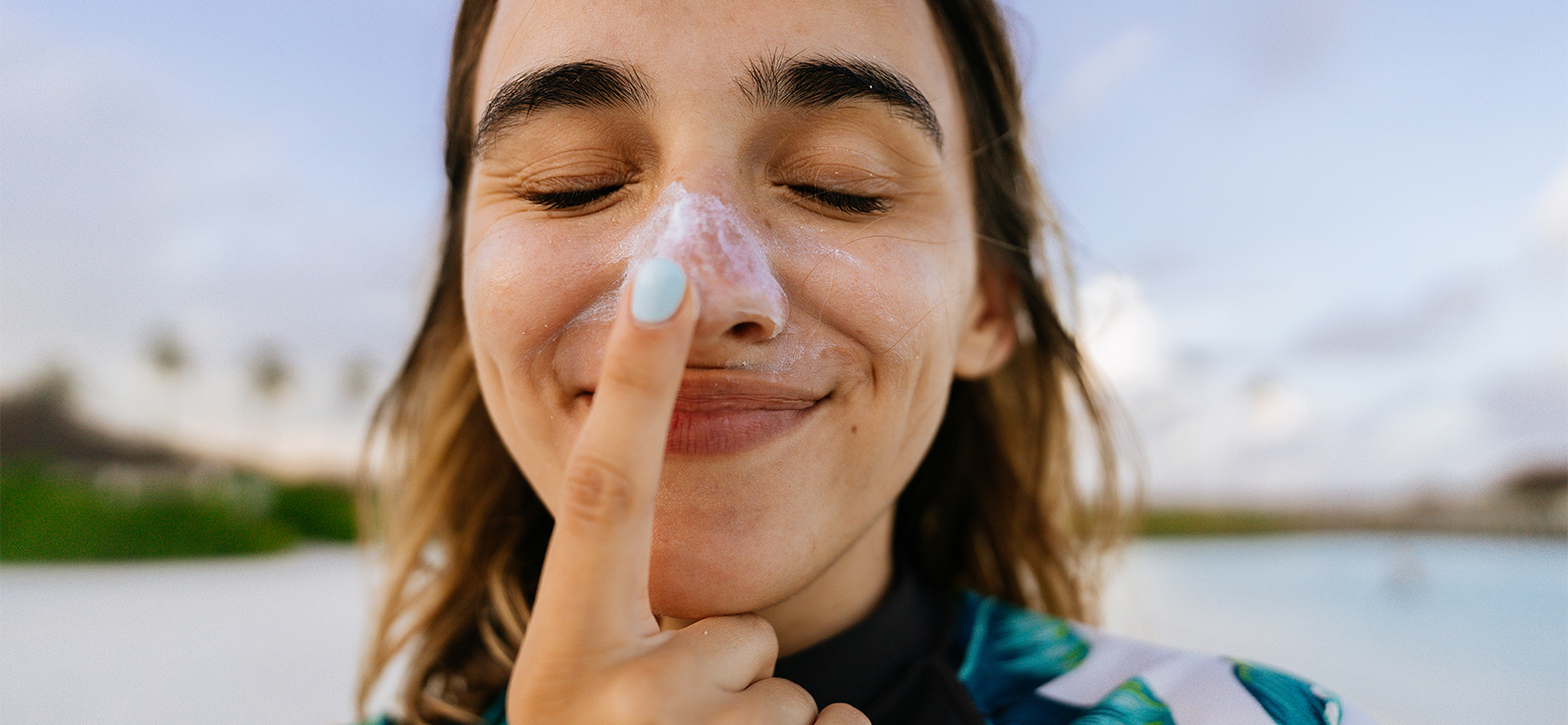 woman putting sunscreen on her nose