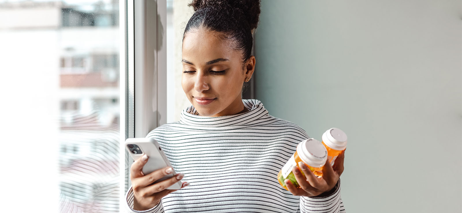 A photo of a woman holding pills.