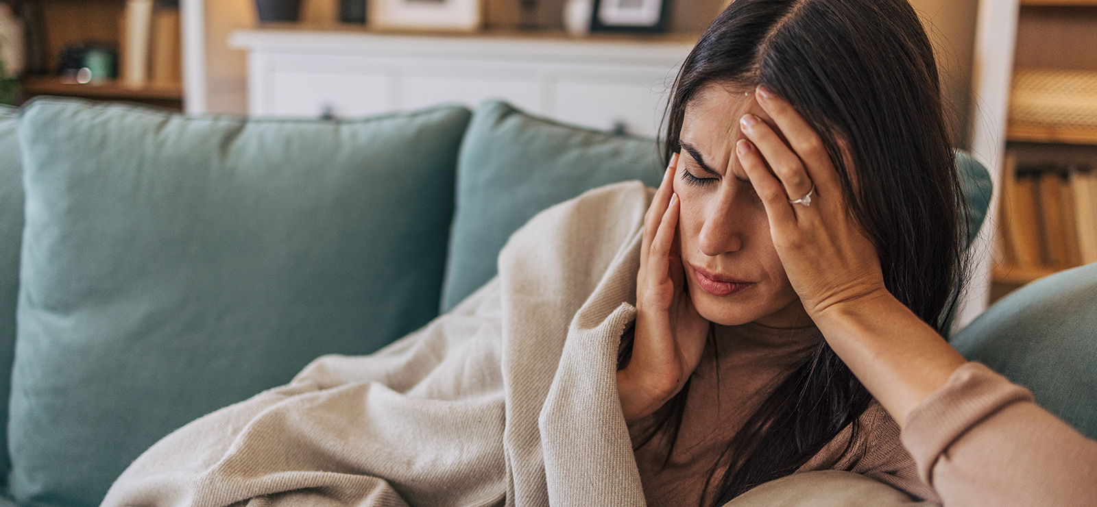 A photo of a woman holding her head.
