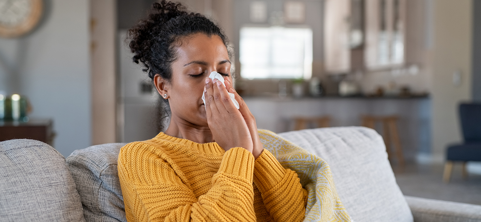 A woman blowing her nose.