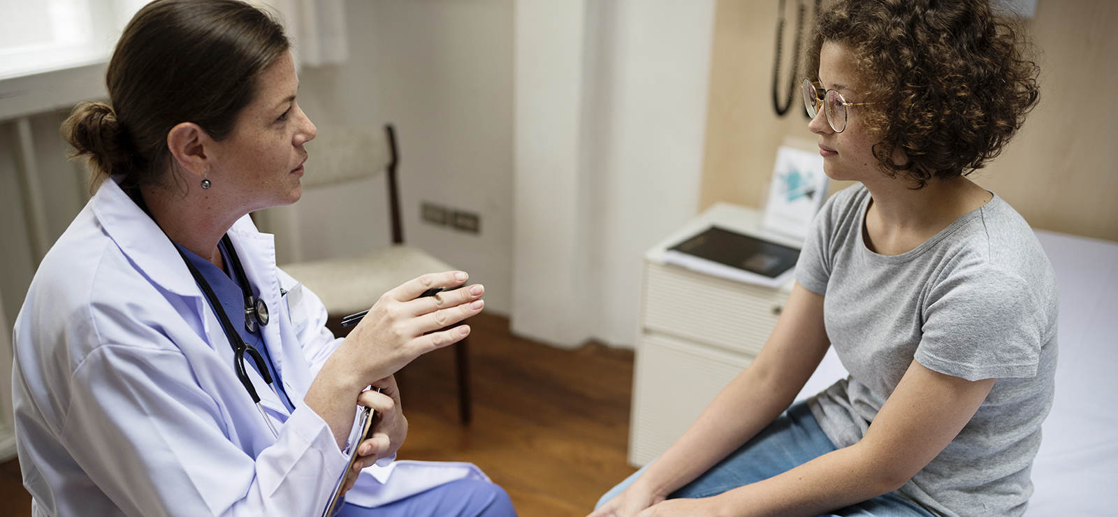 A physician speaking with a woman.