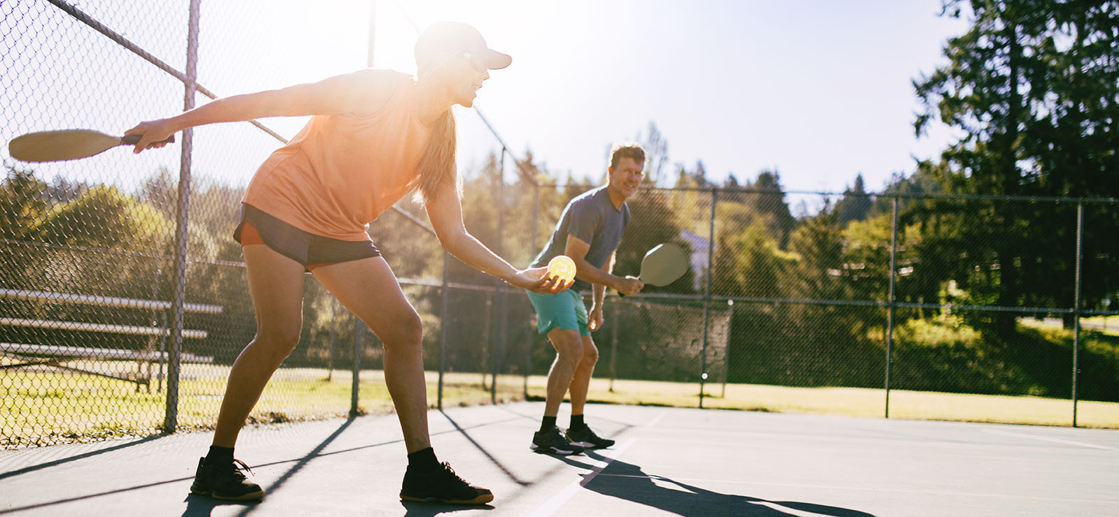 People outdoors playing pickleball.