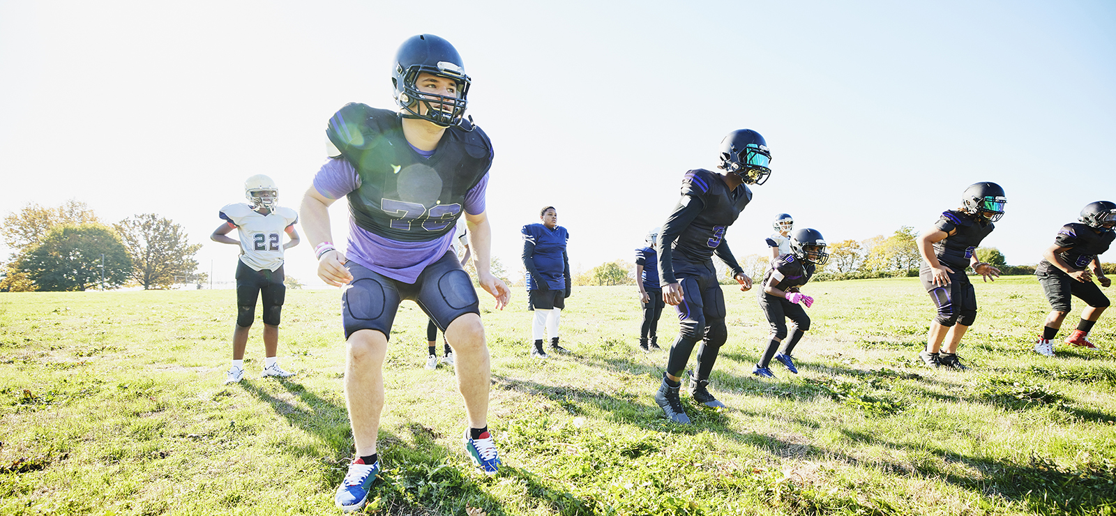 Students outdoors at football practice.