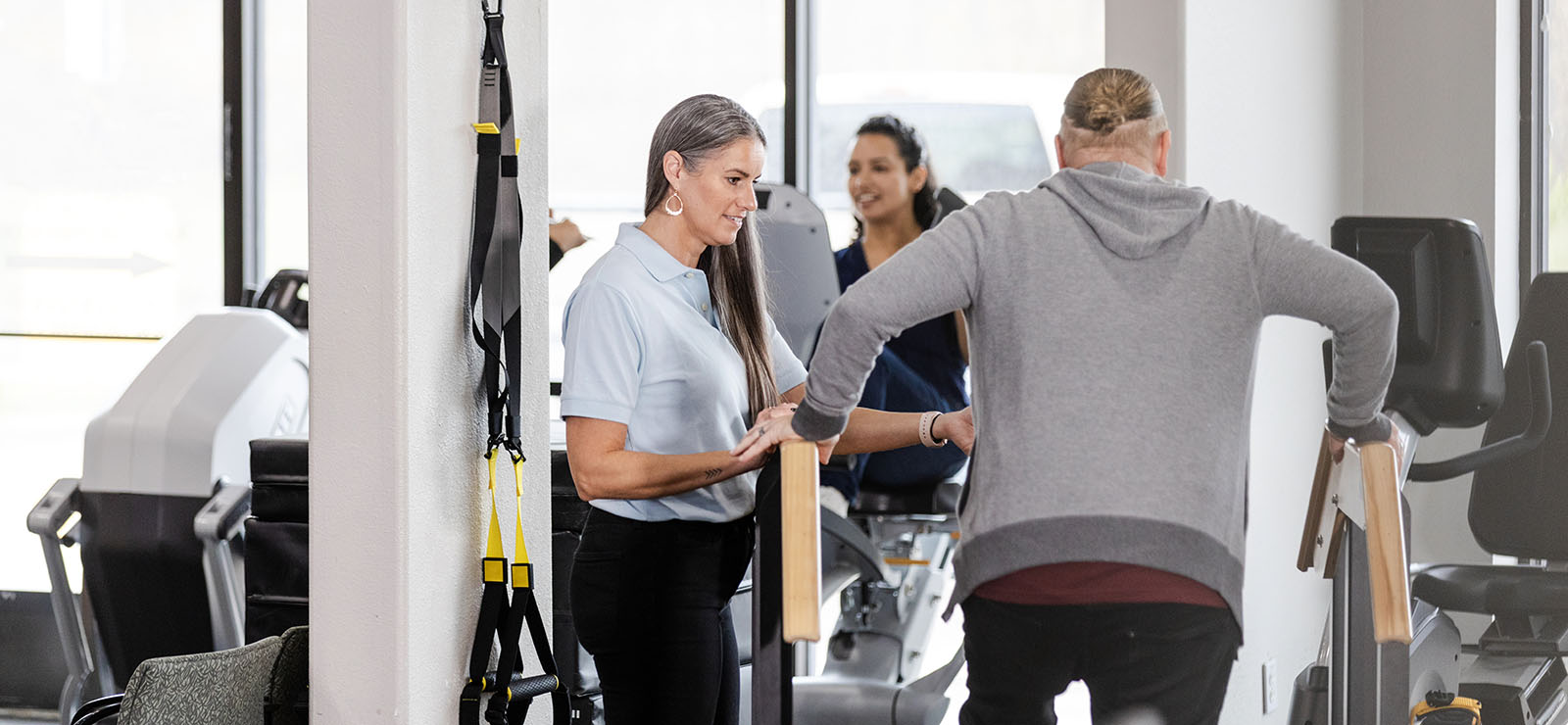 People exercising on some fitness equipment.