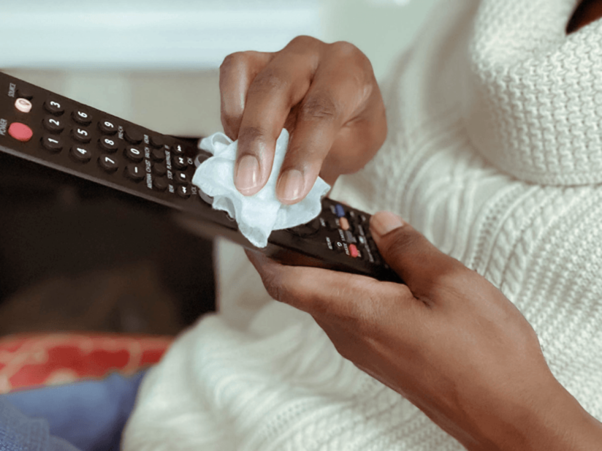 Woman wiping remote control