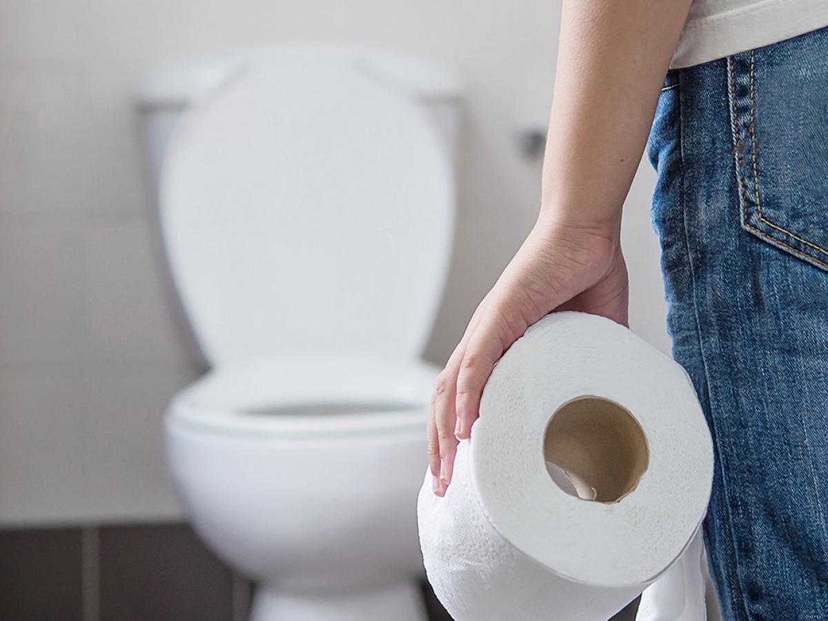 person at toilet with toilet paper