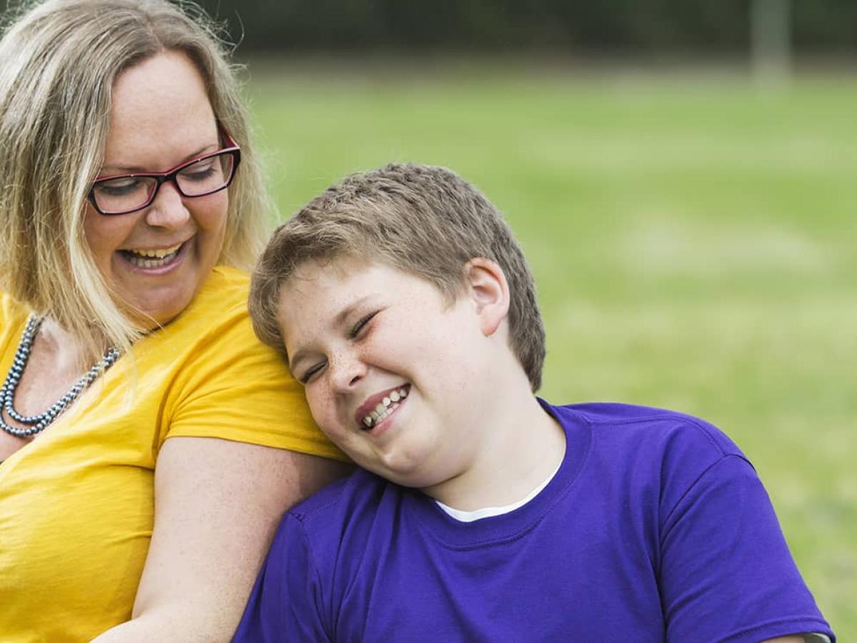 Mother and son sitting outside laughing