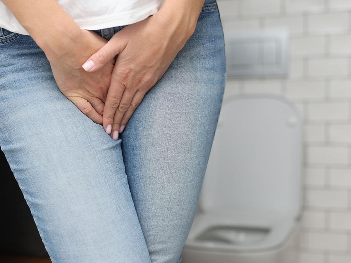 Woman standing uncomfortably due to weak pelvic floor