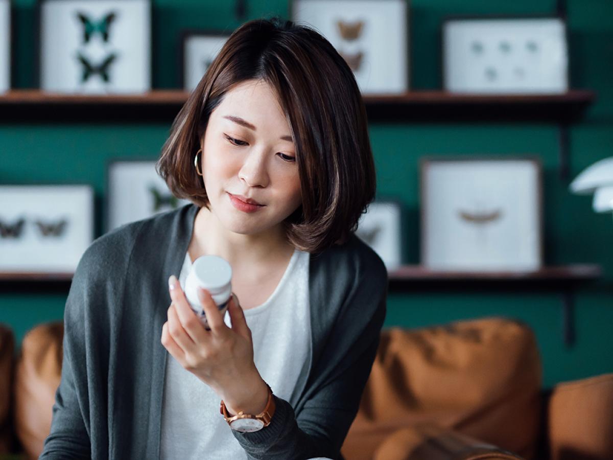 woman looking at pill bottle