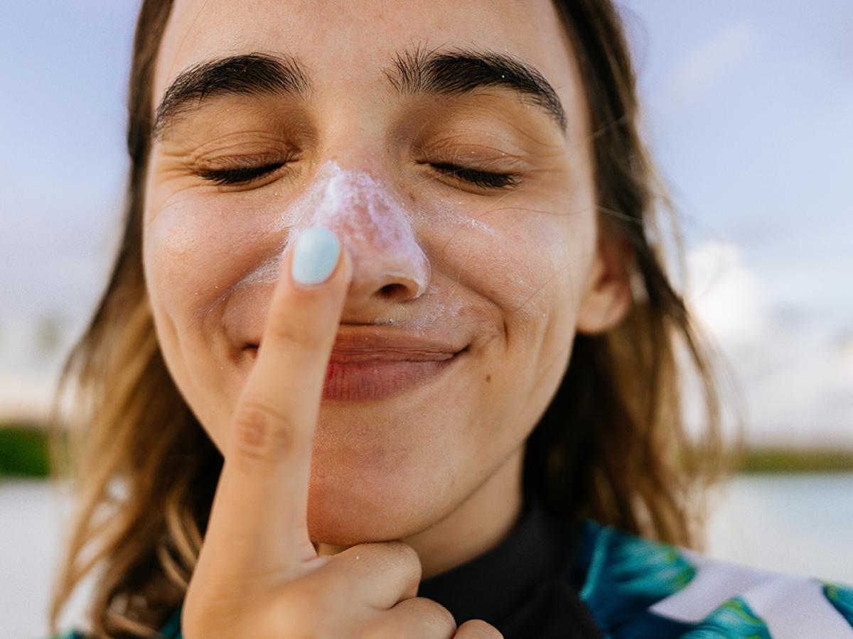 woman putting on sunscreen