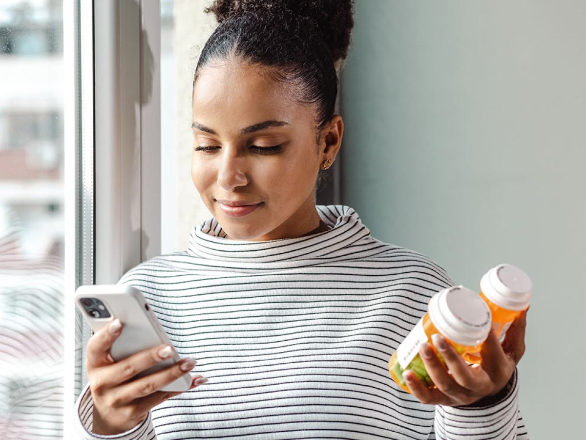 This is an image of a woman holding a bottle of pills.