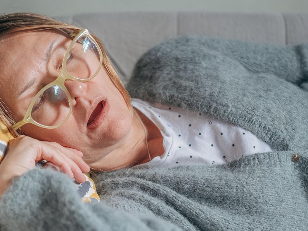 A photo of a woman asleep on the couch.