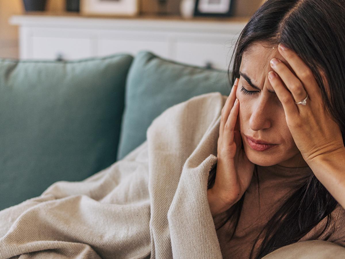 A photo of a woman holding her head.