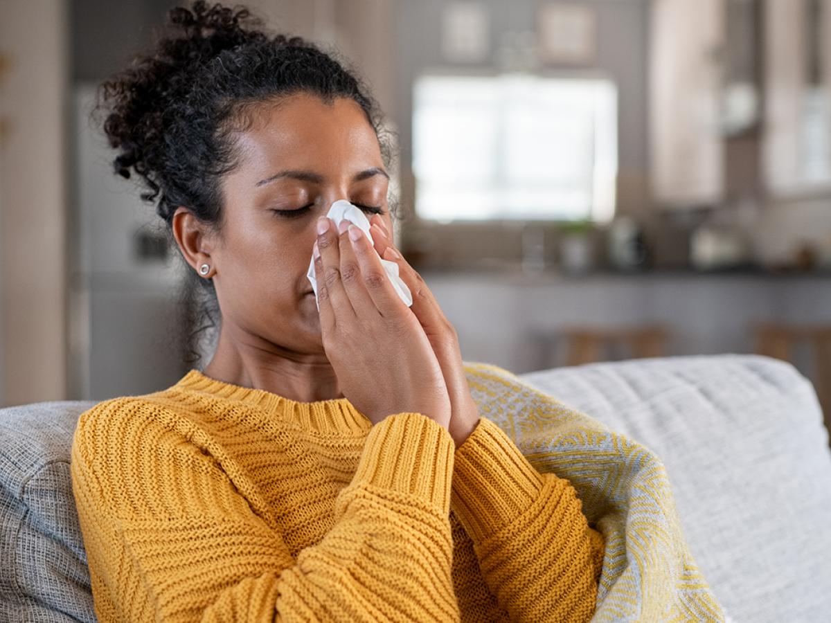 A woman blowing her nose.