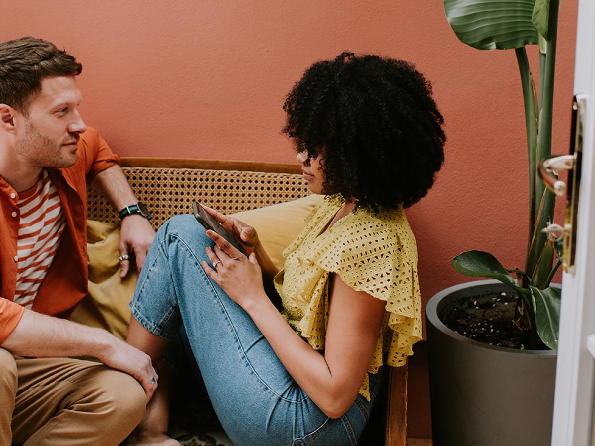 A man and a woman sitting on a sofa.