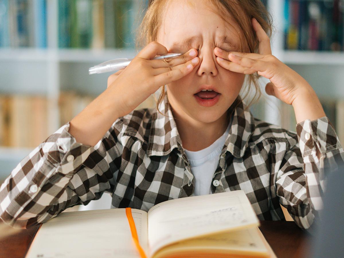 A little girl rubbing her eyes.