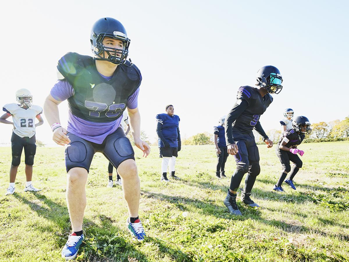 Students outdoors at football practice.