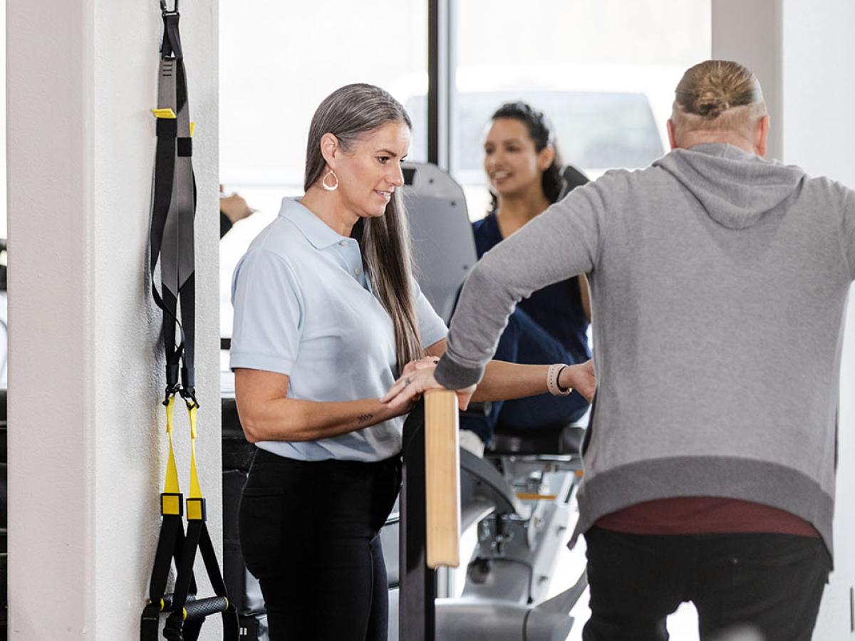 People exercising on some fitness equipment.
