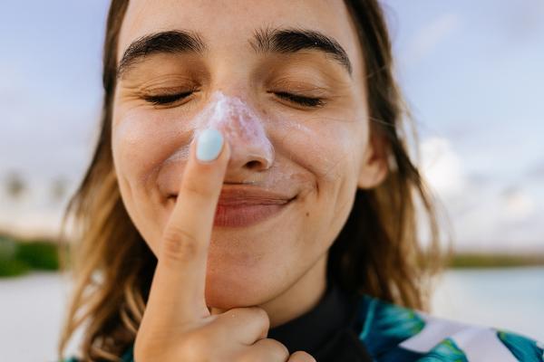 woman putting on sunscreen