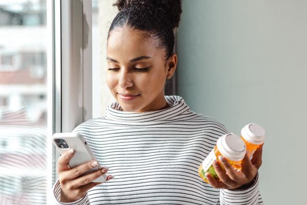 This is an image of a woman holding a bottle of pills.