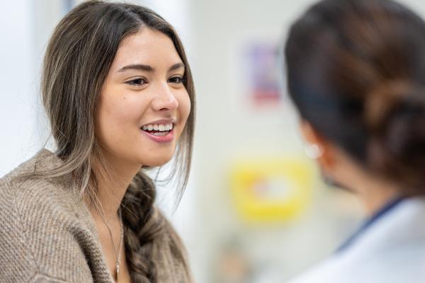 A woman talking to a primary care physician.