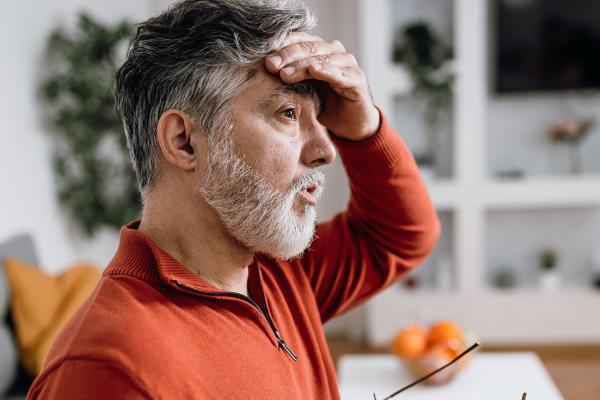 A man wiping his forehead.