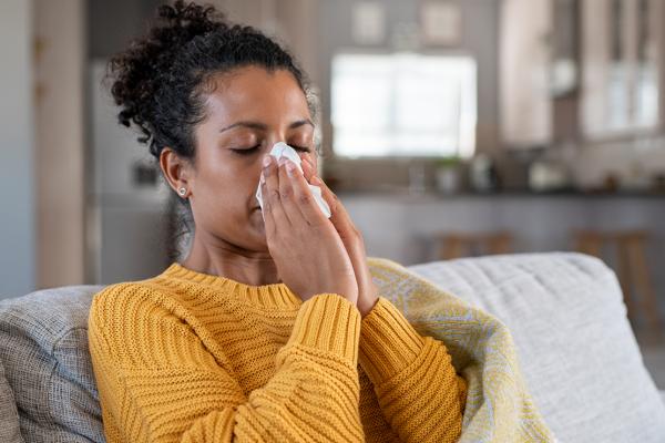 A woman blowing her nose.