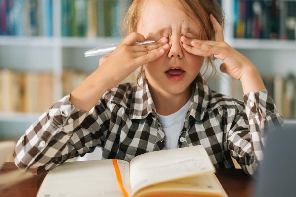 A little girl rubbing her eyes.