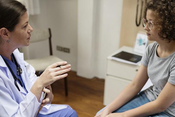 A physician speaking with a woman.