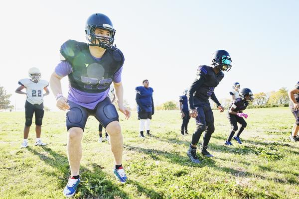 Students outdoors at football practice.