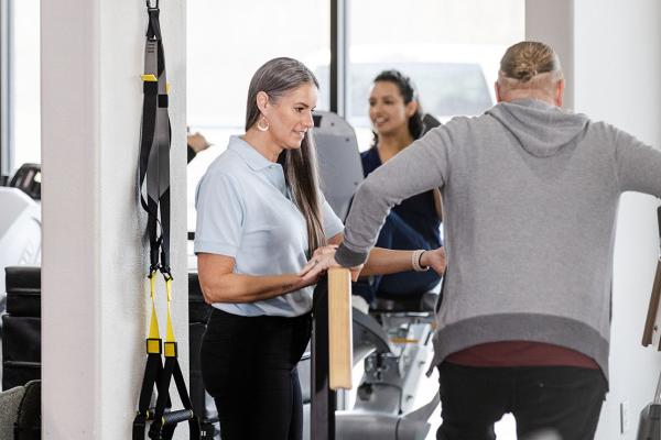 People exercising on some fitness equipment.