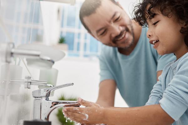 A father teaching his son how to wash his hands.