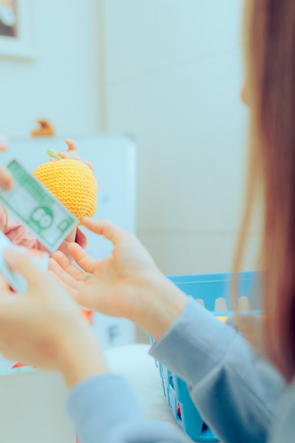 A mother and child playing toy money.