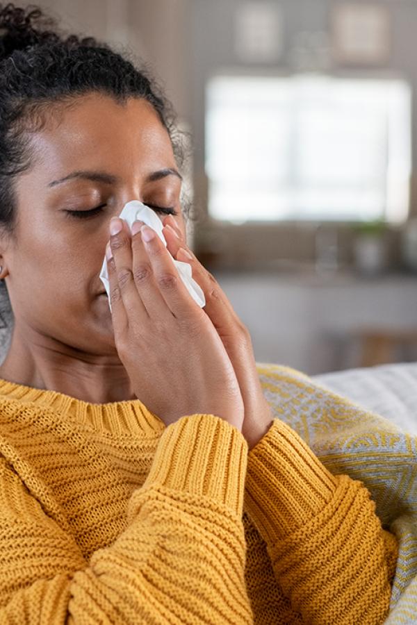 A woman blowing her nose.