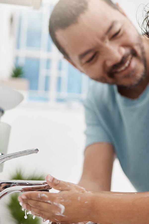 A father teaching his son how to wash his hands.