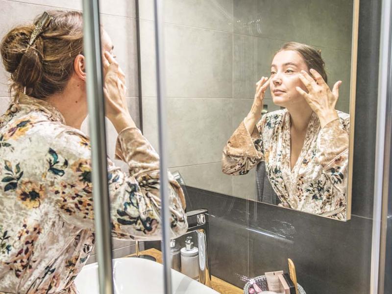 Woman looking at her face in the mirror