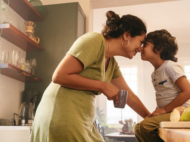 A mother and child in the kitchen.