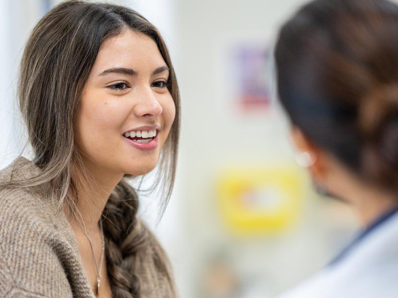A woman talking to a primary care physician.