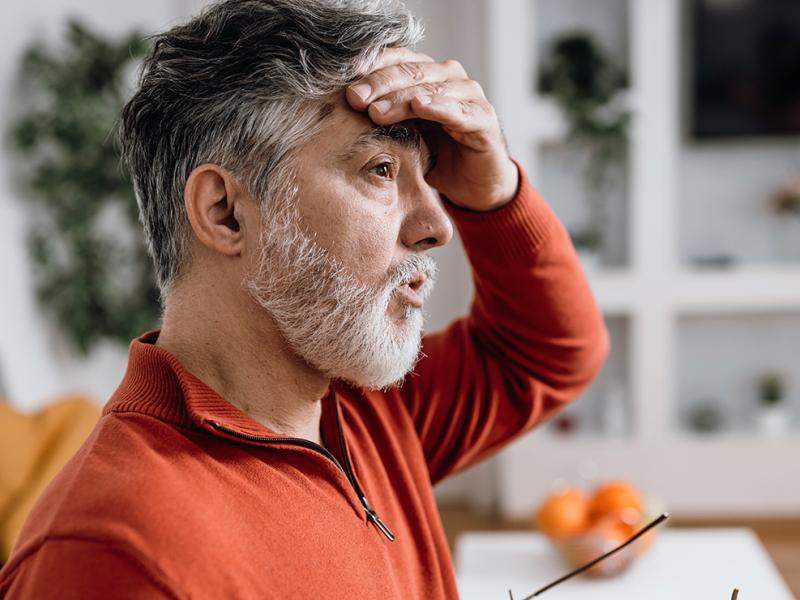 A man wiping his forehead.