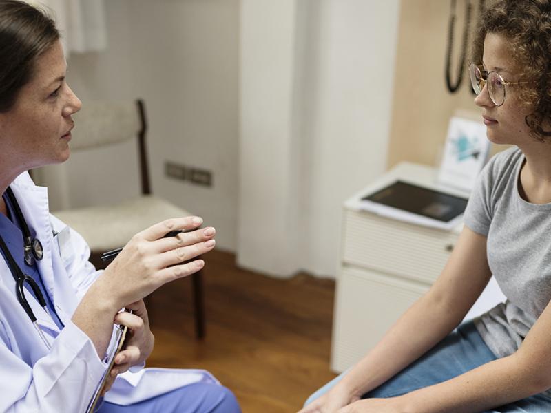A physician speaking with a woman.