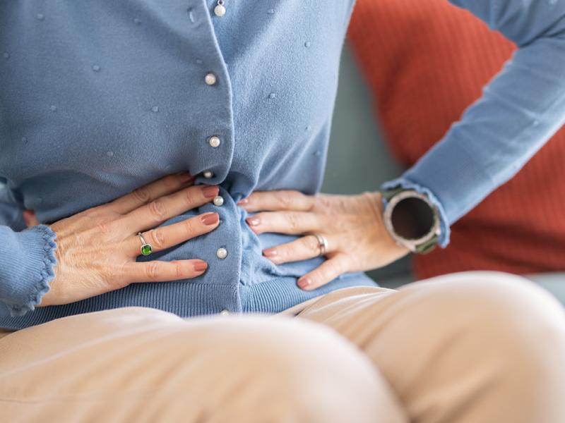 A photo of a person gripping their stomach.